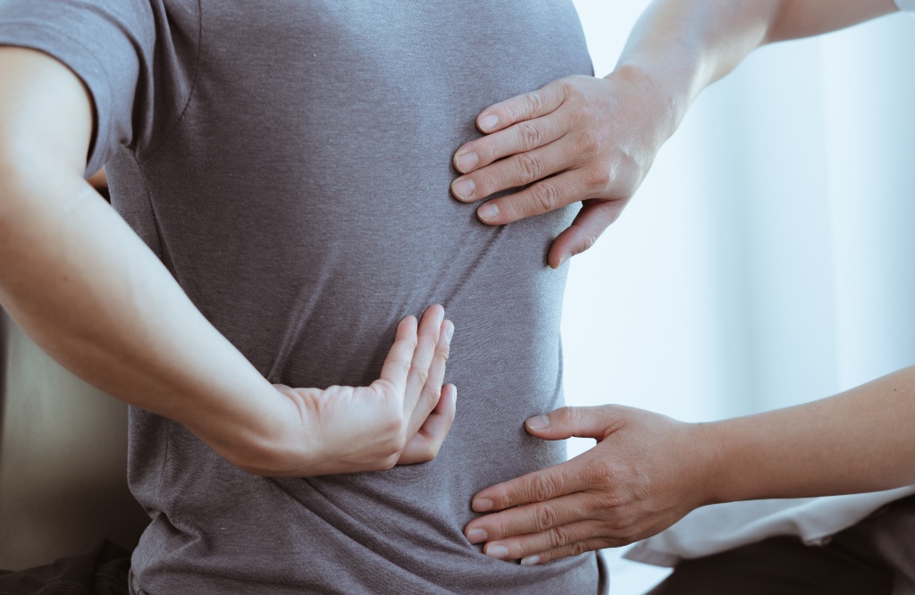 physical therapist examines back pain and spinal area