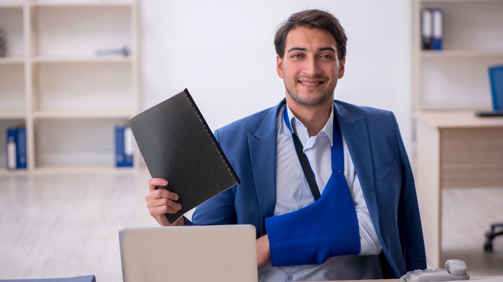 Young male employee after car accident at workplace
