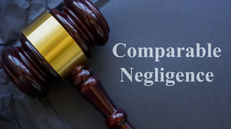 Wooden judge's gavel with gold band on dark surface next to text "Comparable Negligence".