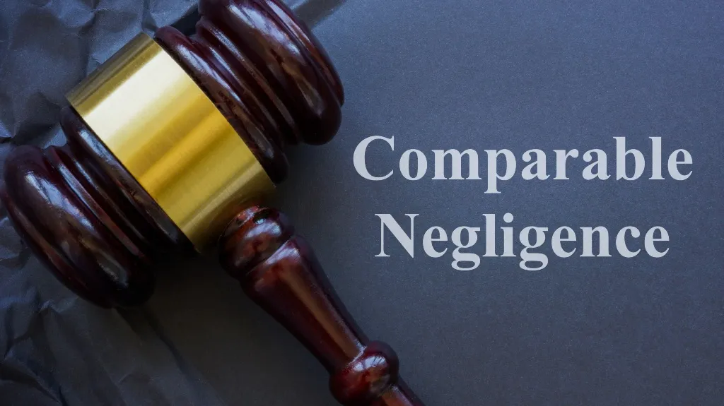 Wooden judge's gavel with gold band on dark surface next to text "Comparable Negligence".